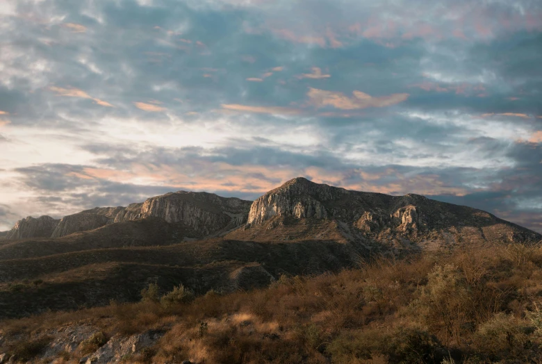 a very tall mountain with some clouds in the sky