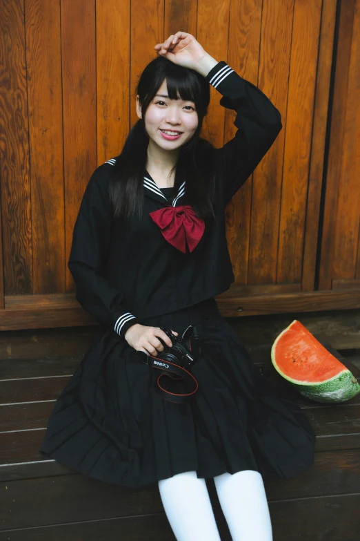 a young asian girl sitting by a wooden door