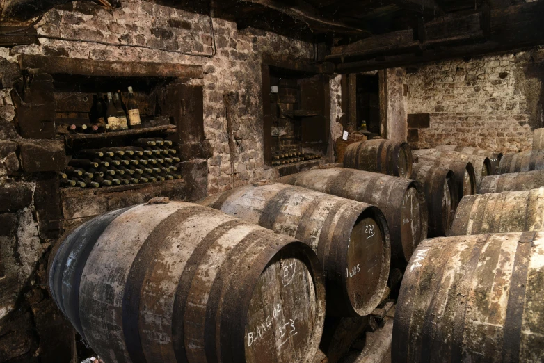 a group of old barrels sitting in a cellar
