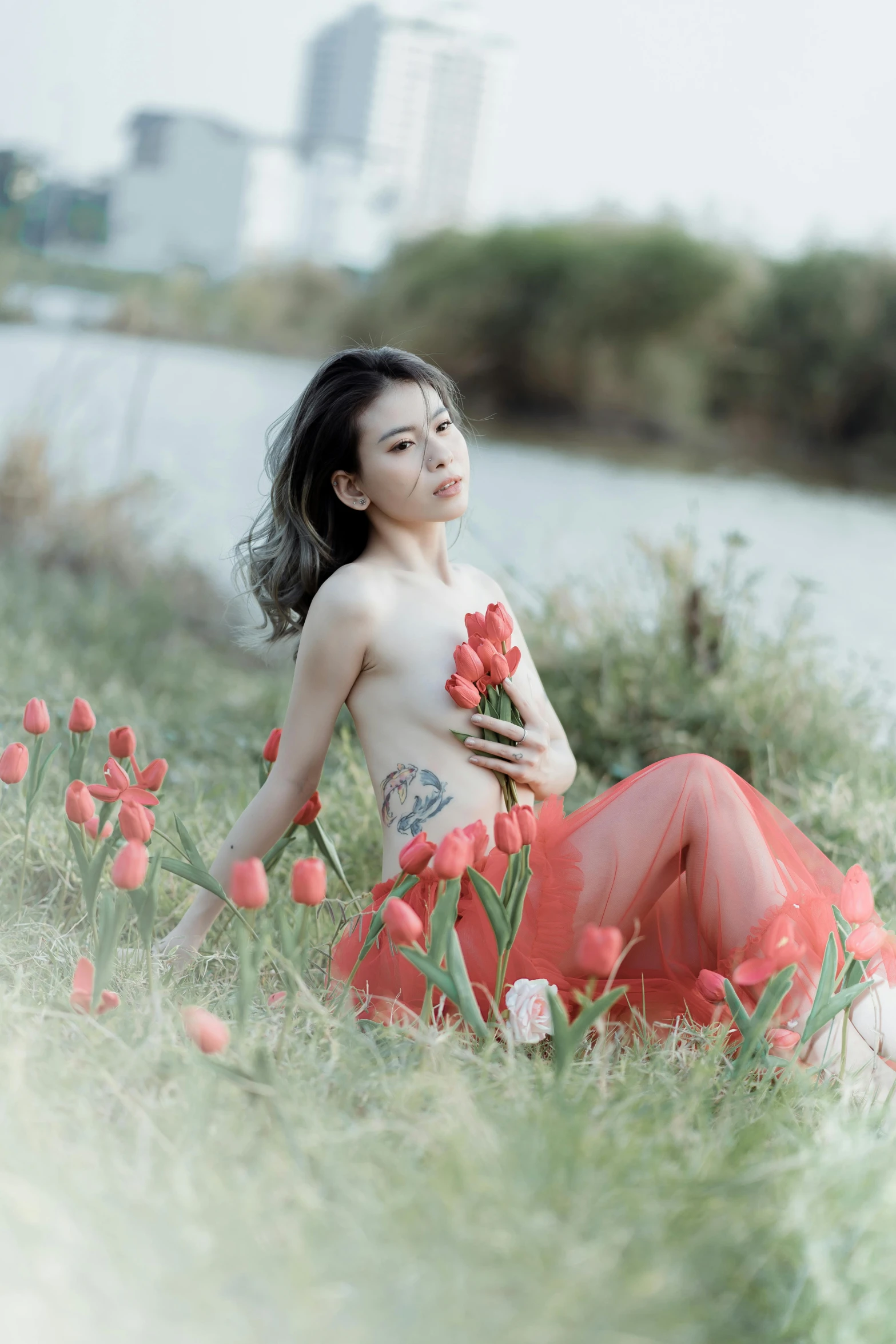 a woman in a red skirt kneeling down next to some water