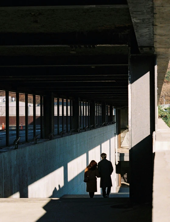 an overpass that has a couple walking underneath it