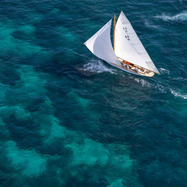 a small sail boat sailing through the ocean