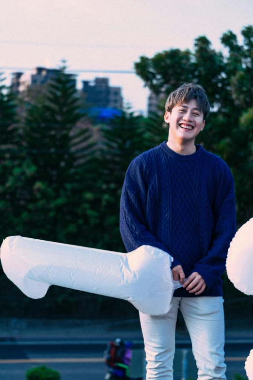 the boy is holding a giant white item