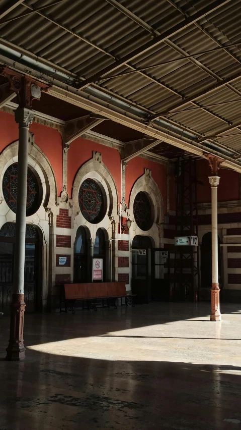 an empty courtyard area with arched windows and benches