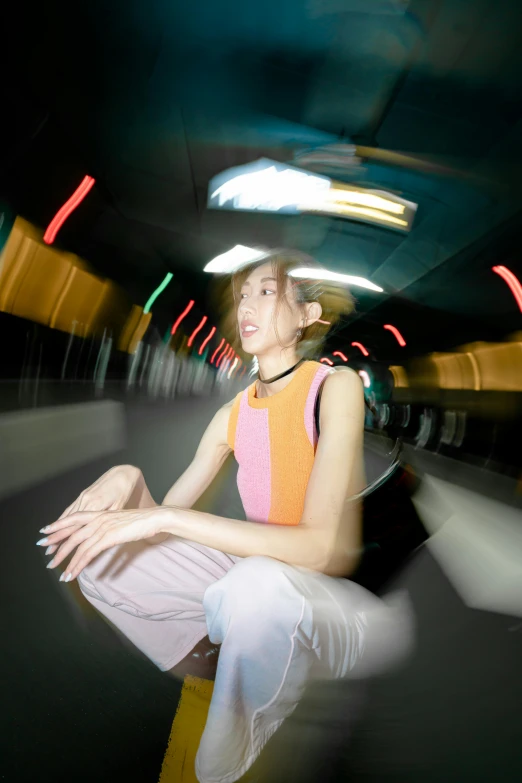 woman with a hat and shirt sitting on the ground in a subway car