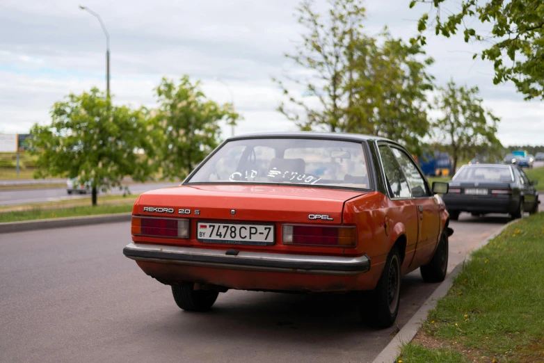 a red car that is parked by the side of a road