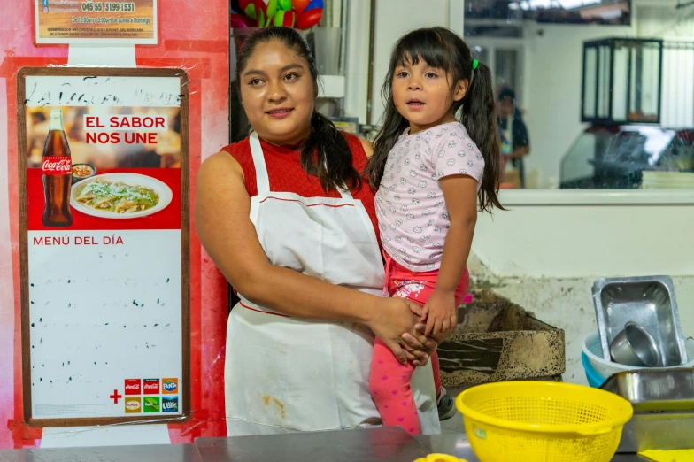 a woman and a child standing in front of a sign