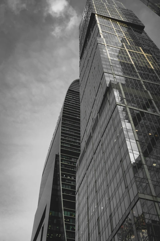 two skyscrs next to each other against a cloudy sky