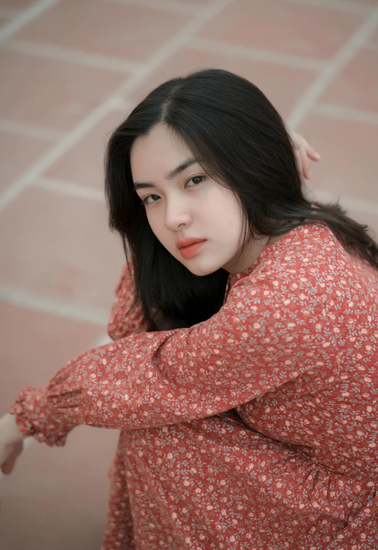 a woman with long hair and wearing a floral top