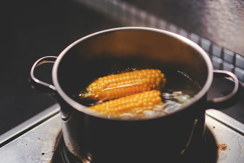 a pot of corn is on the stove while cooking