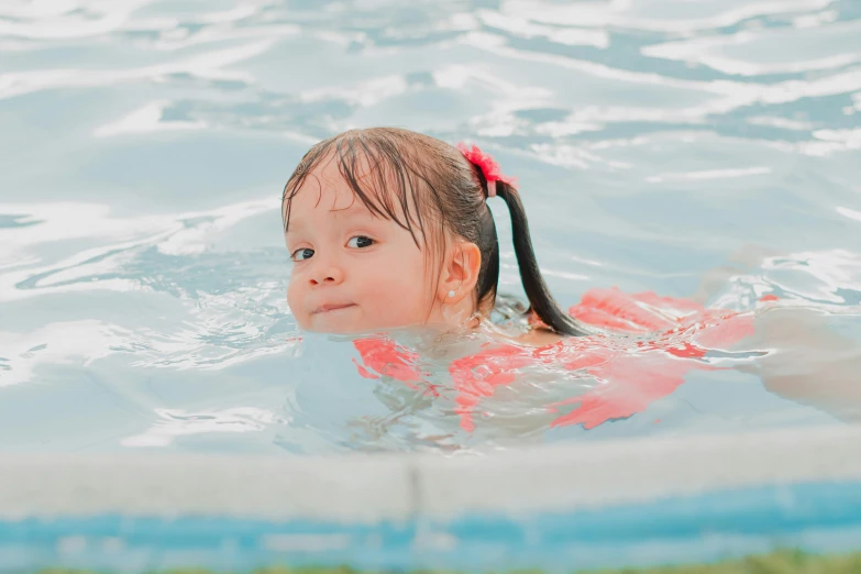  in swimming pool with a big ponytail looking ahead