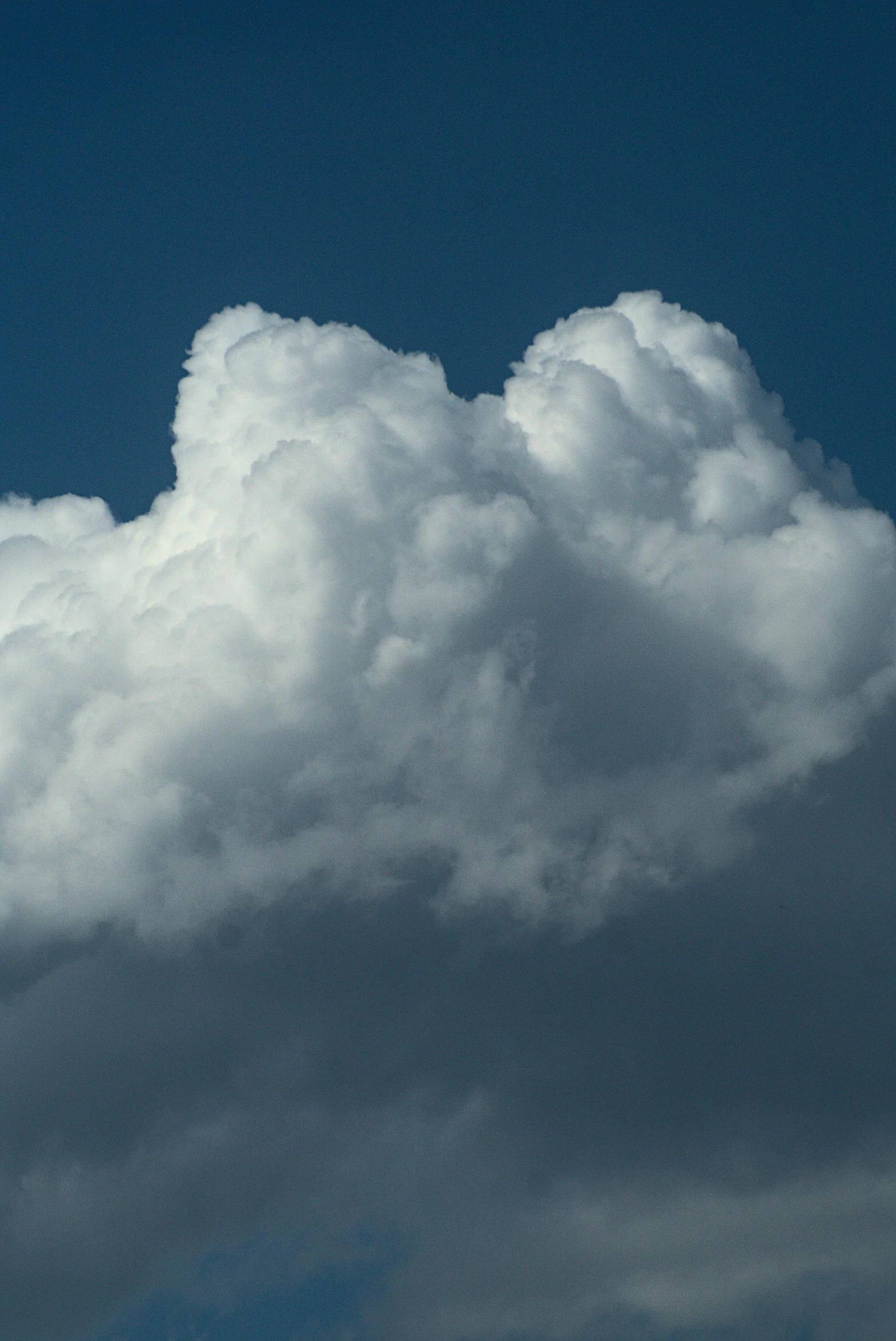 a jet airplane flies through the air while partly covered in clouds