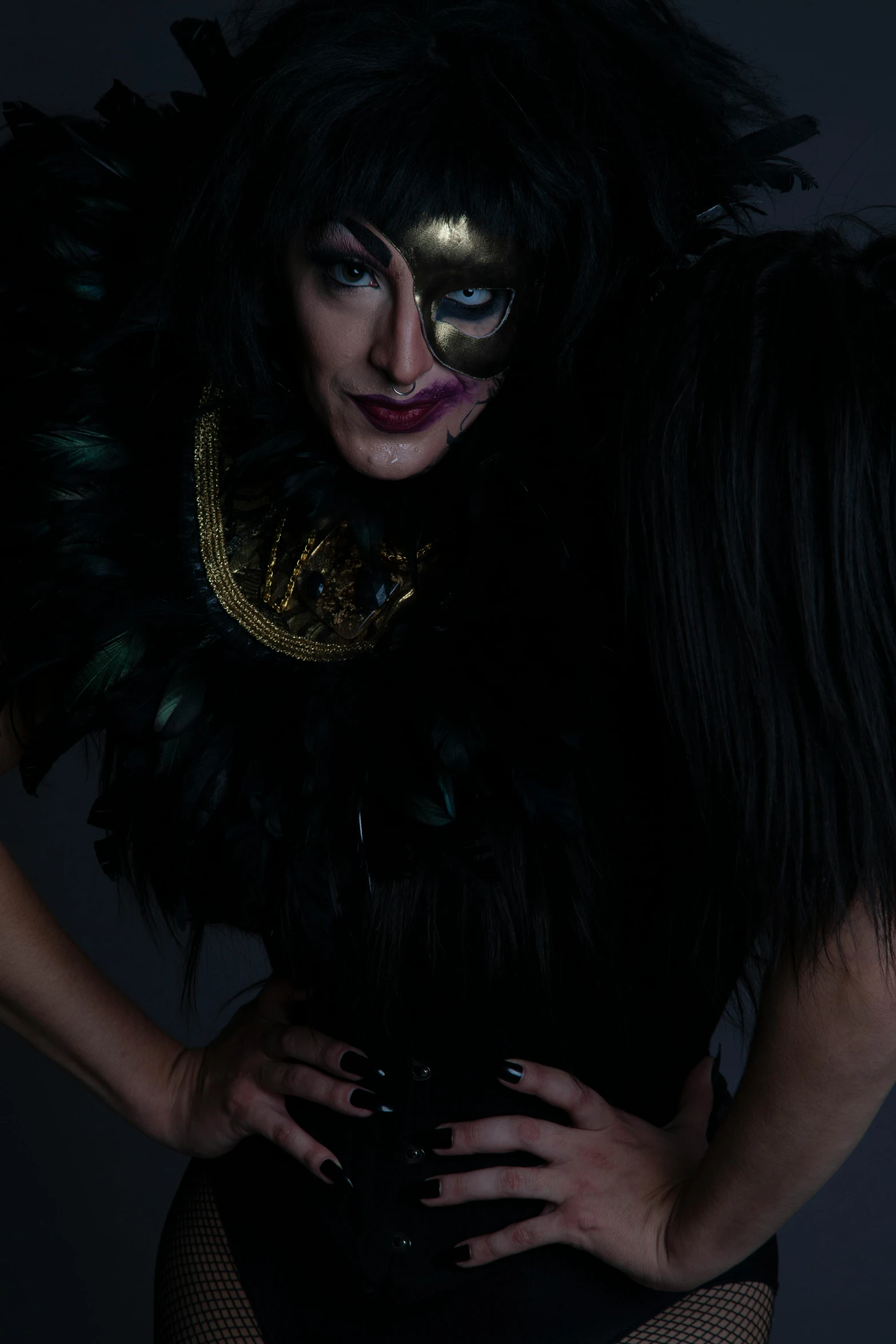 a woman in feathered costume standing and looking at the camera