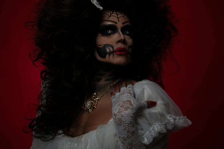 a woman wearing white with black makeup and long hair