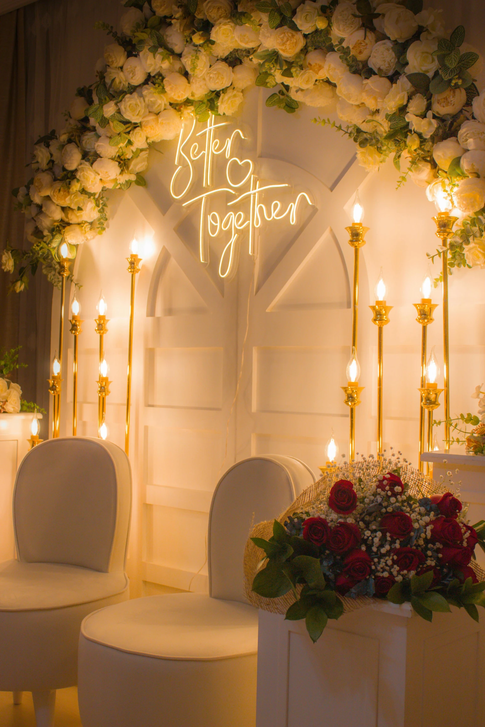 a room that has flowers and white chairs with a lightening up sign