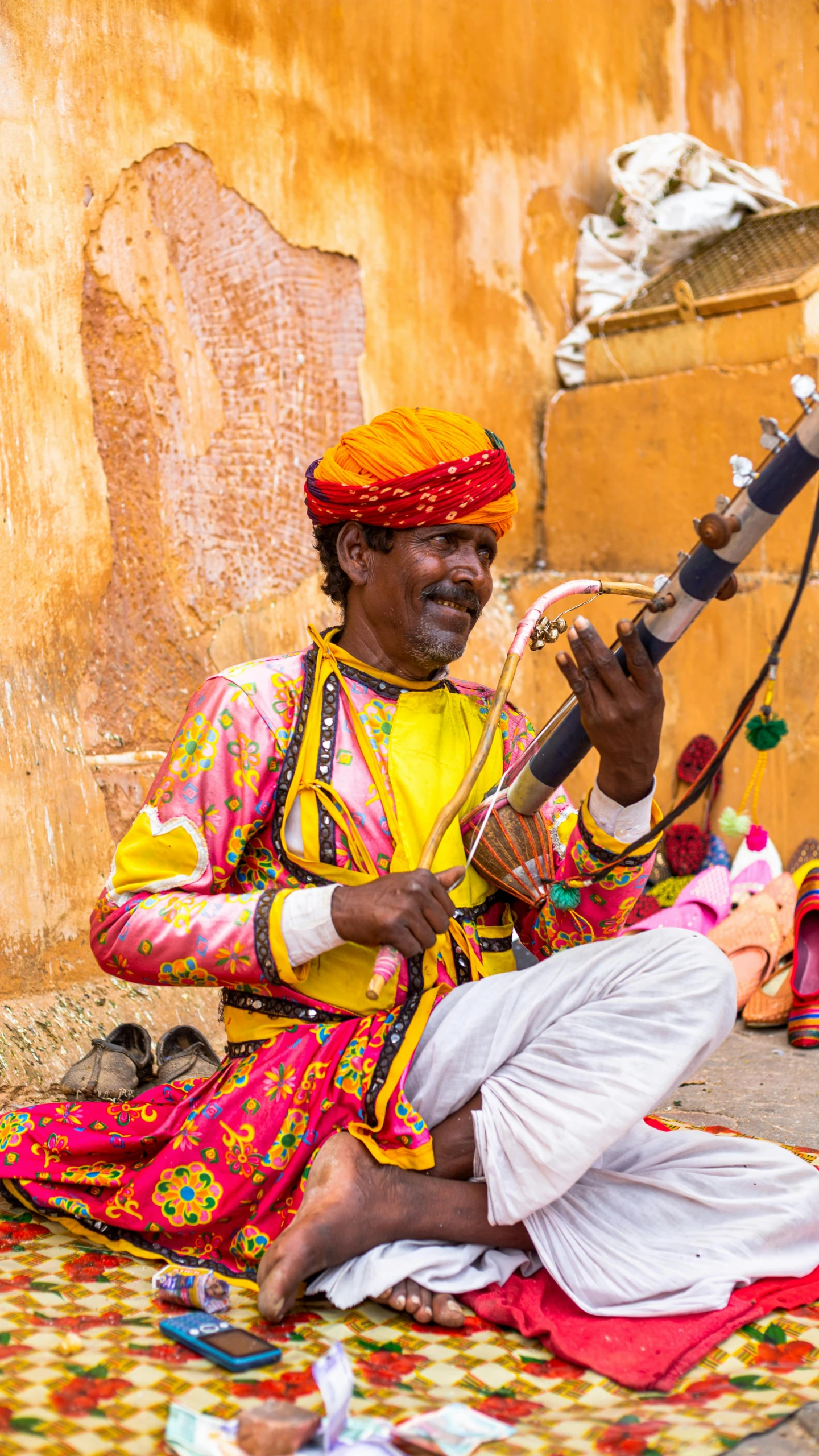 a man sitting on the ground playing an instrument