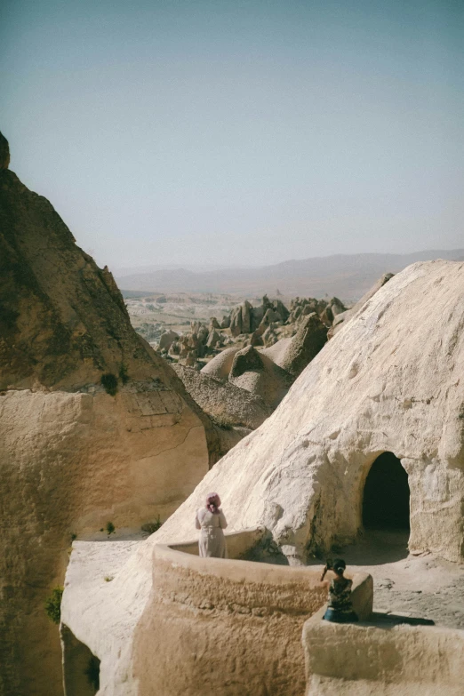 people sit on the edge of a rock cave