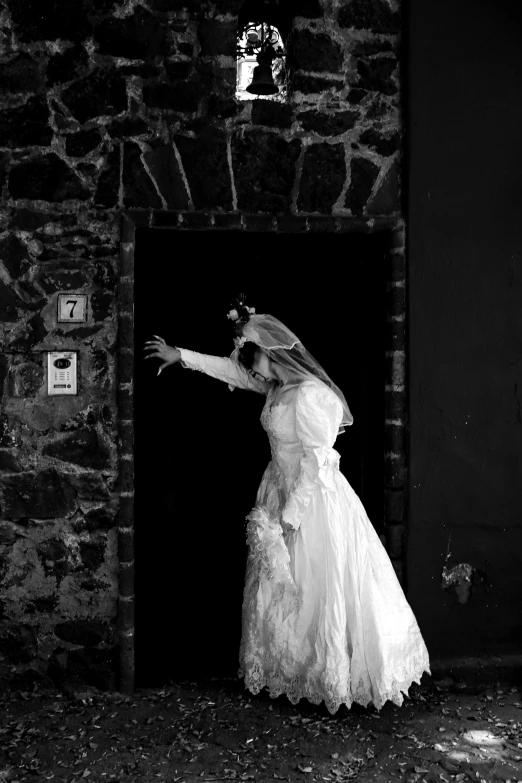 a bride poses in a doorway before walking into her wedding gown