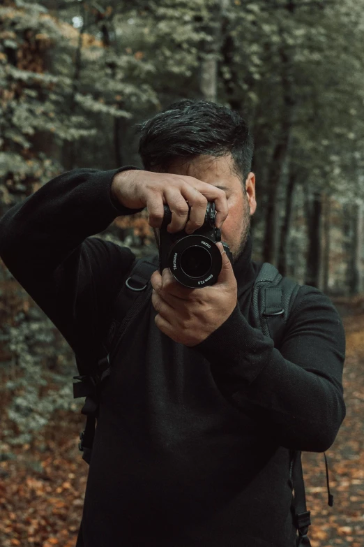 a man with his camera in the woods