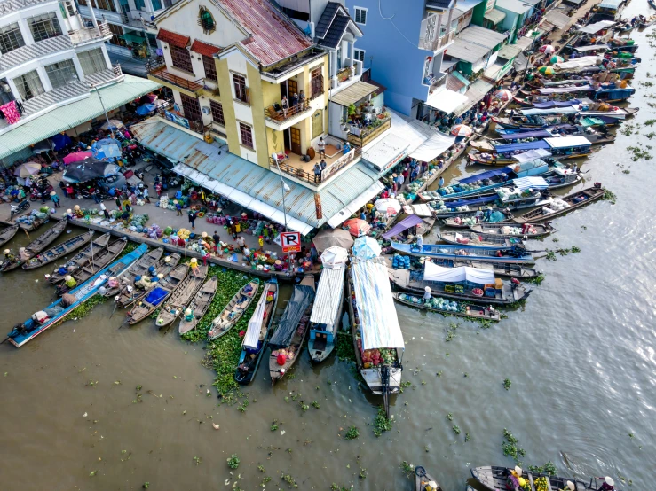 large buildings with many boats on a muddy waterway