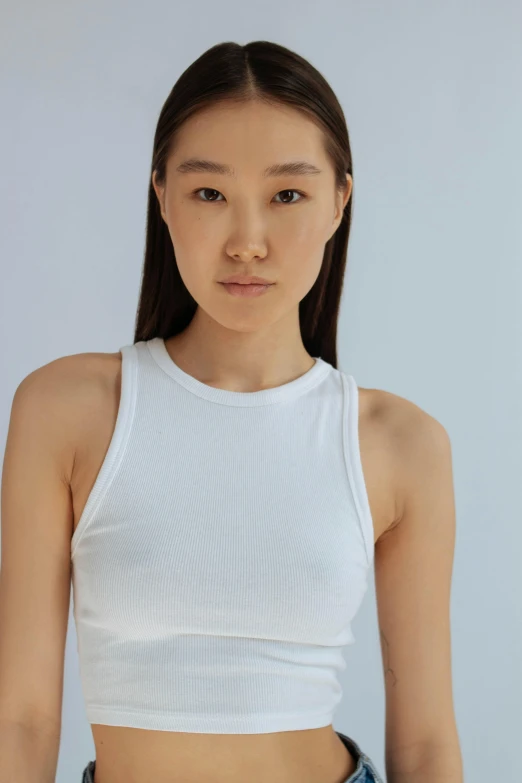 a young woman is standing in front of a wall