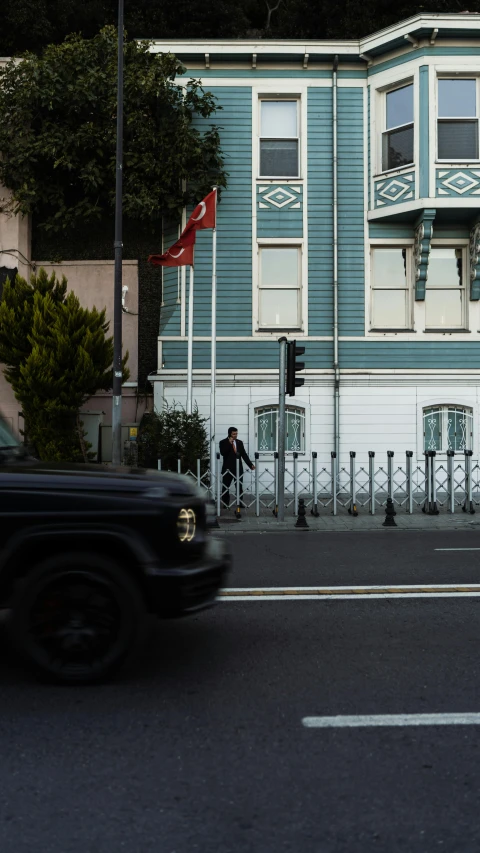 a car traveling past a tall blue building