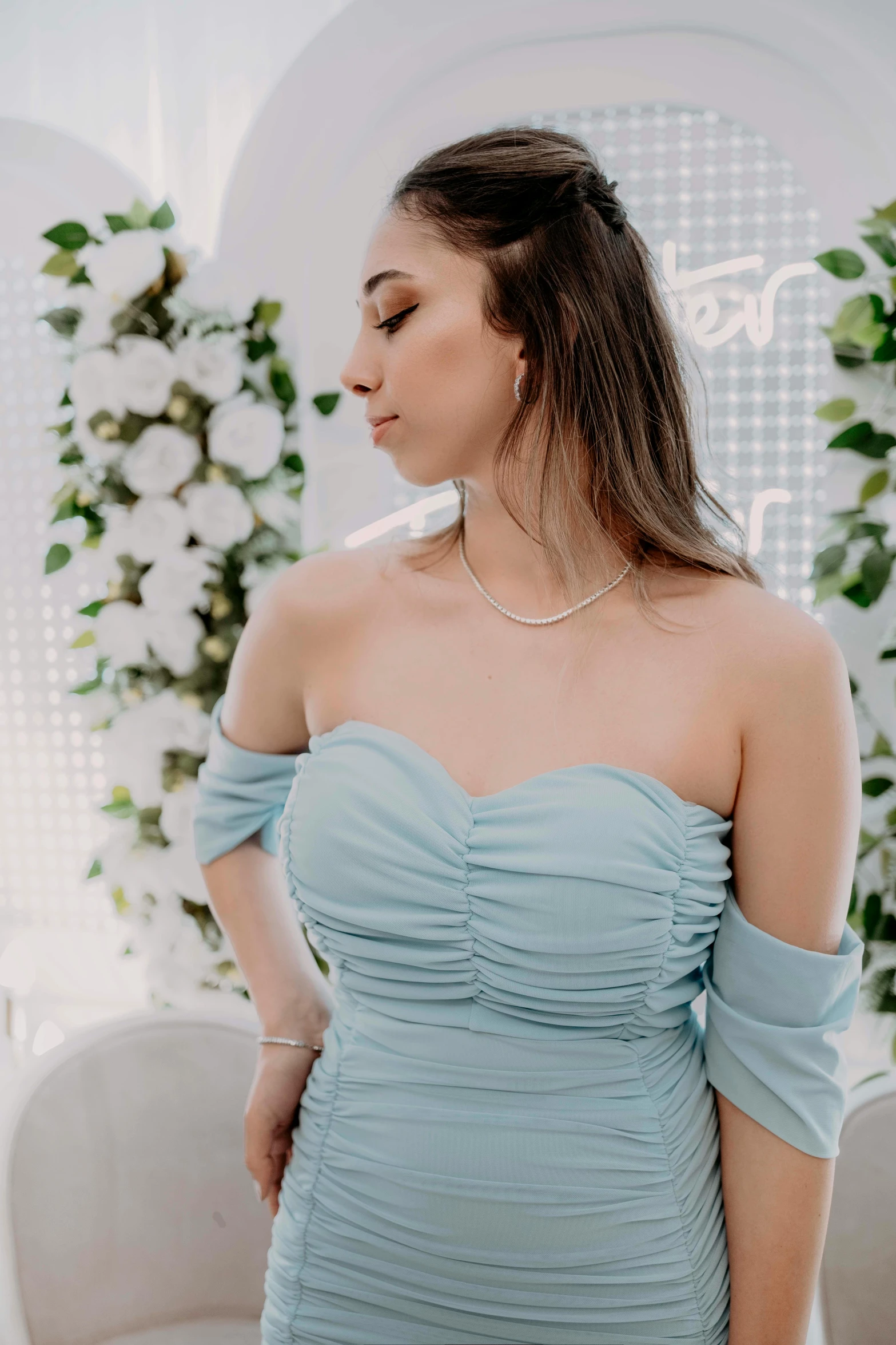 a woman in a blue dress in front of flowers