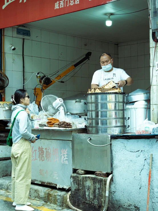 two people working on food on an outdoor kitchen