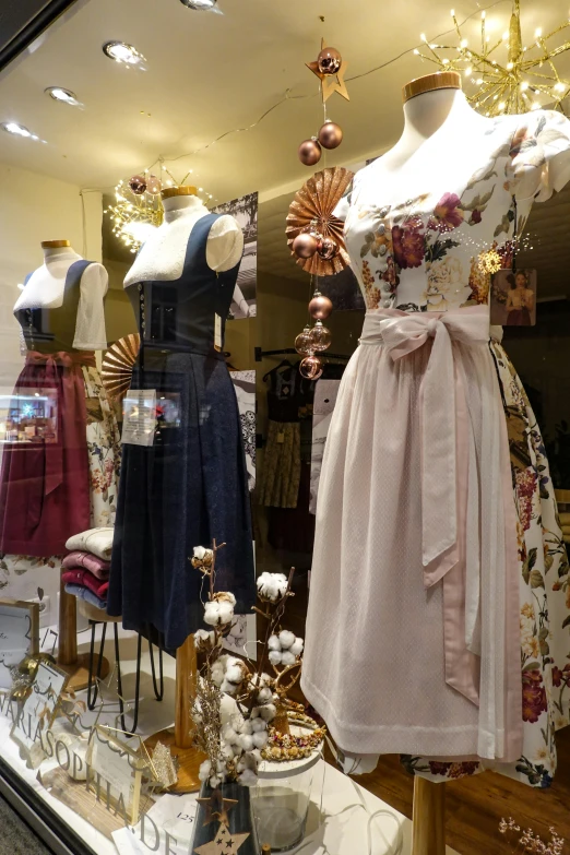 several dresses in various colors on display in a clothing store