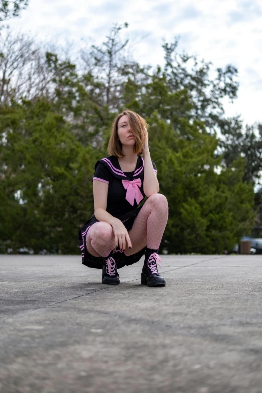 a person squatting down outside in a park