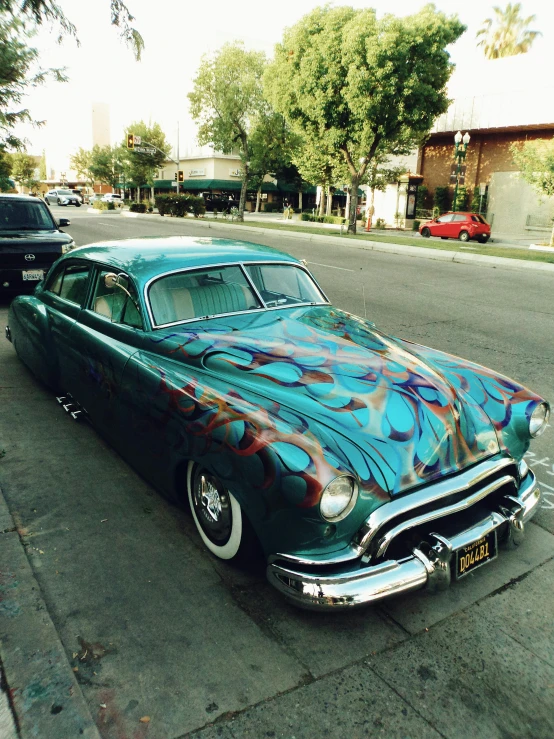 a classic car painted in bright colors with graffiti