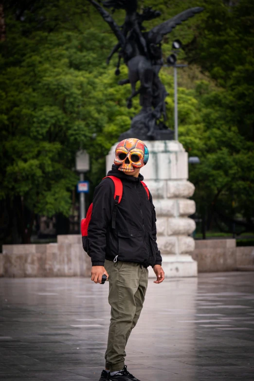 a man with a skull face mask and a black jacket