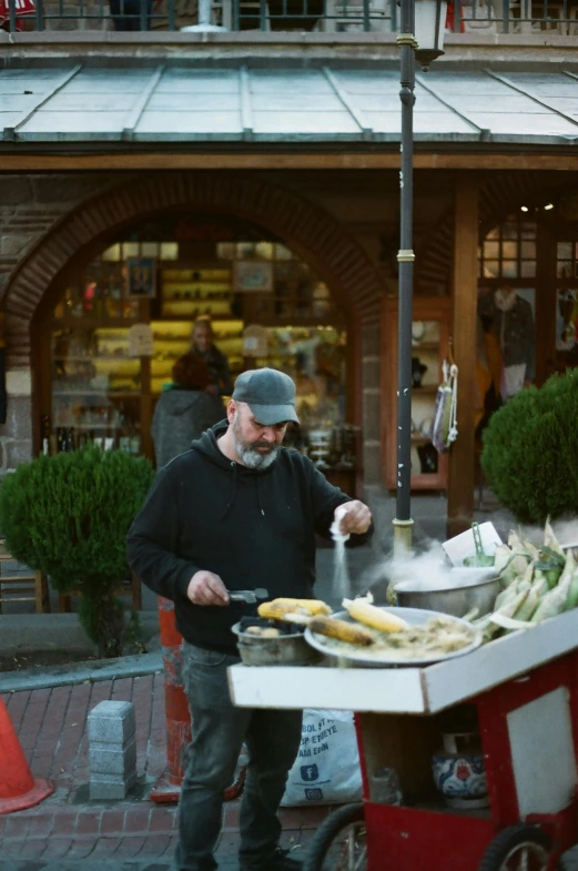 a man with a beard cooking food outside