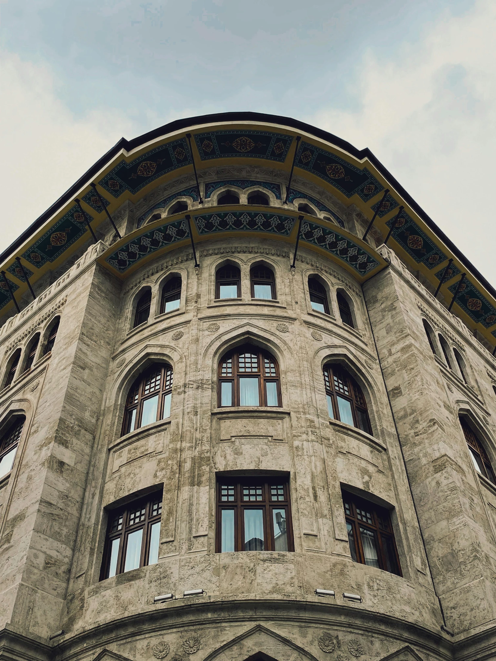 an old, stone - style building with multiple windows on the corner