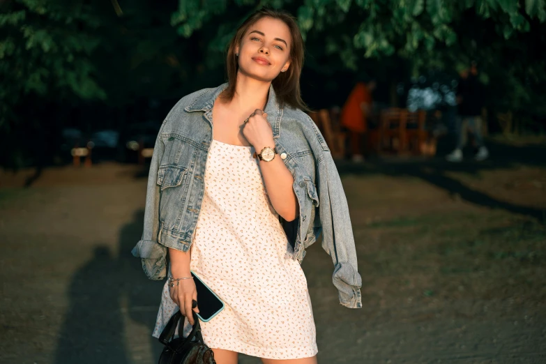 a beautiful young woman posing with her handbag and holding a purse