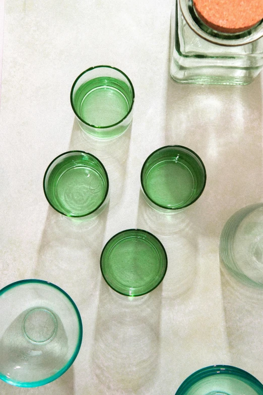 a table filled with a set of five glass cups