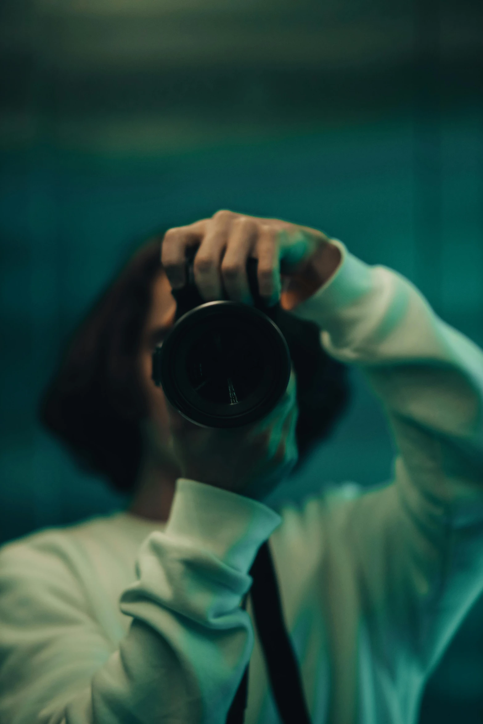 a person taking a picture with a camera in a green room