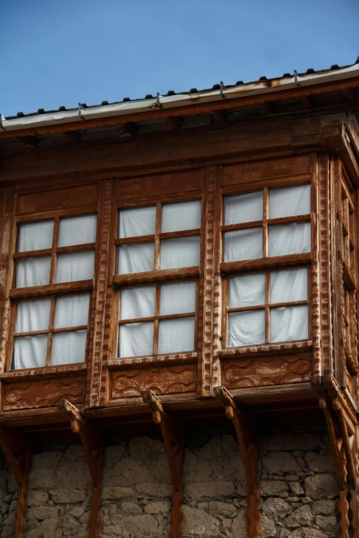 a tall building with multiple windows and a wooden roof