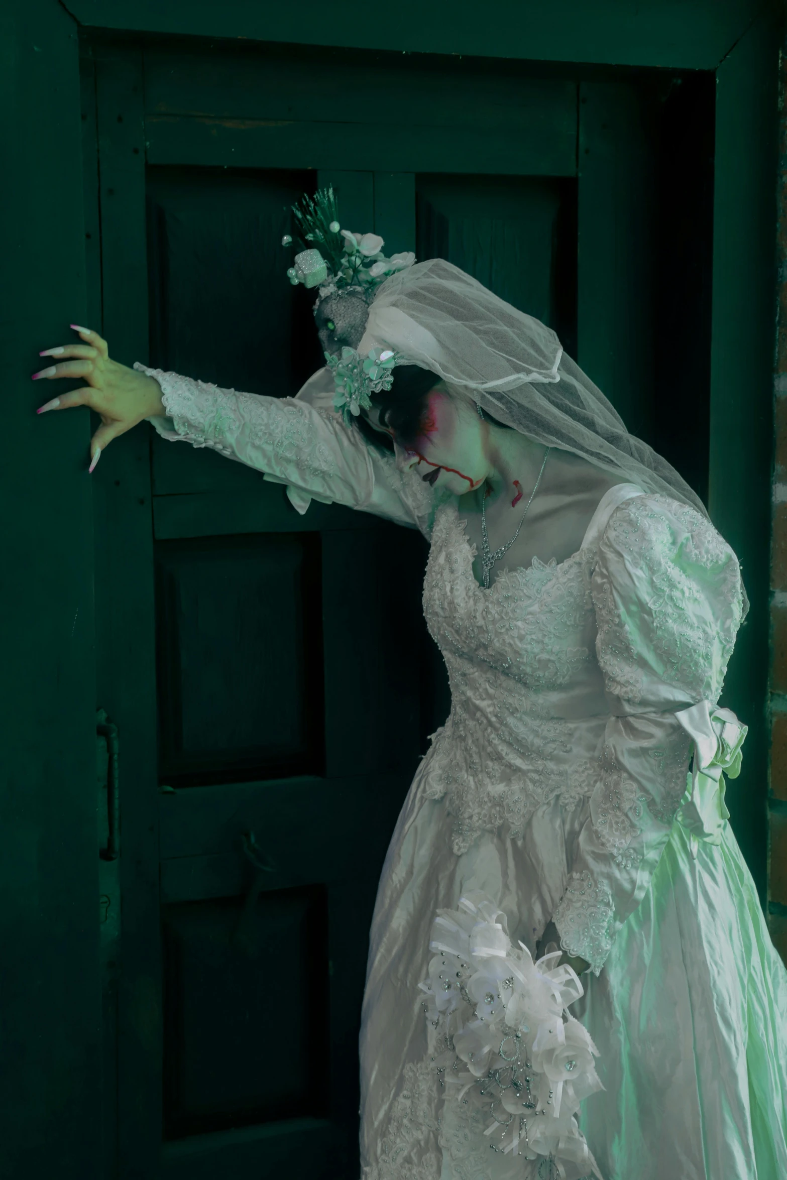 a woman in a wedding dress is leaning against a door