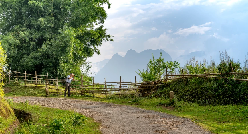 a man standing near a wooden fence