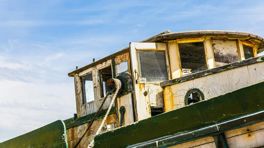 a rusted up green ship with the door and railing