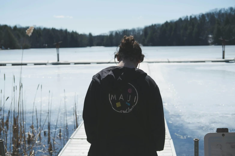 the man walks near a pond with snow