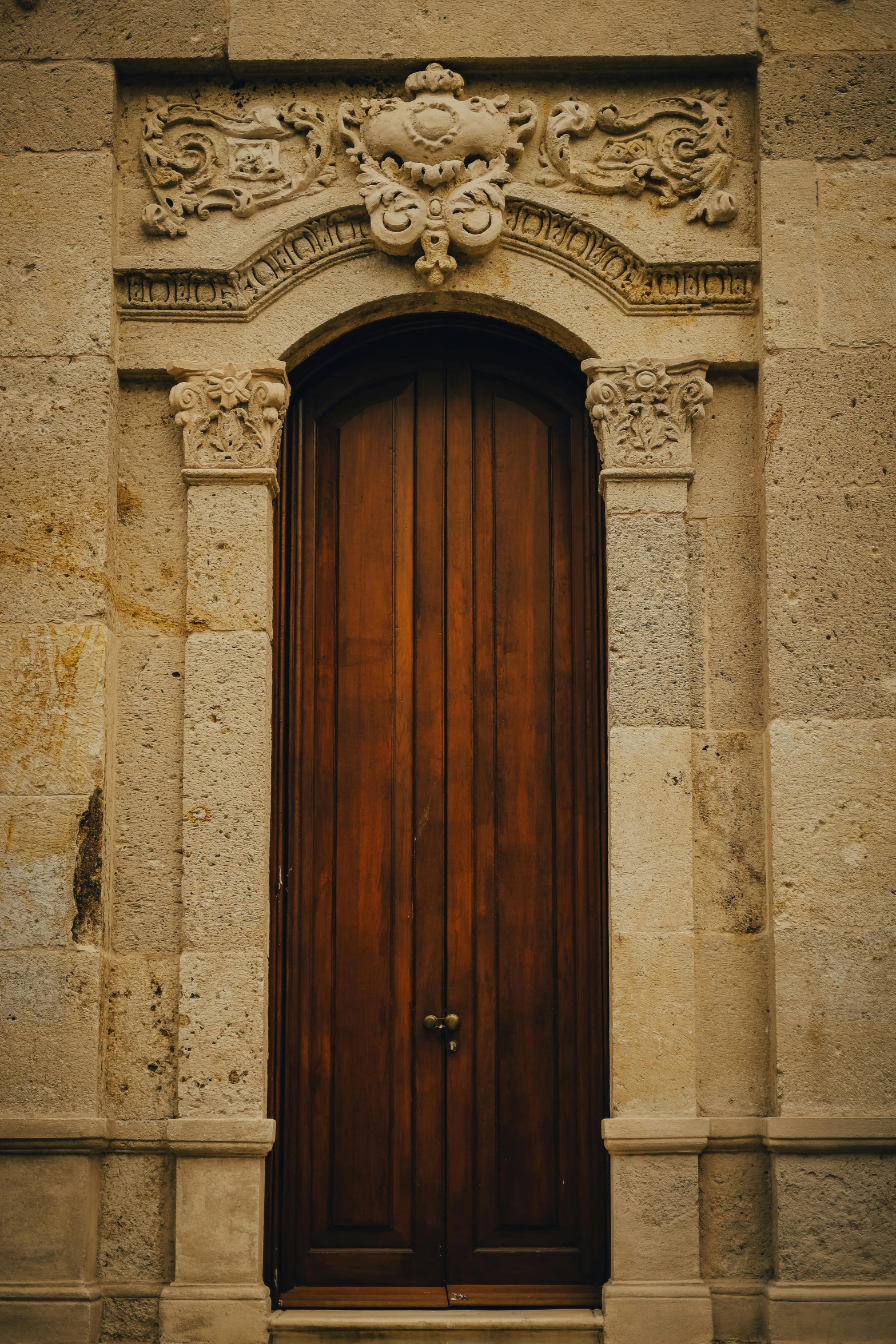 an old fashioned door that is on a stone wall