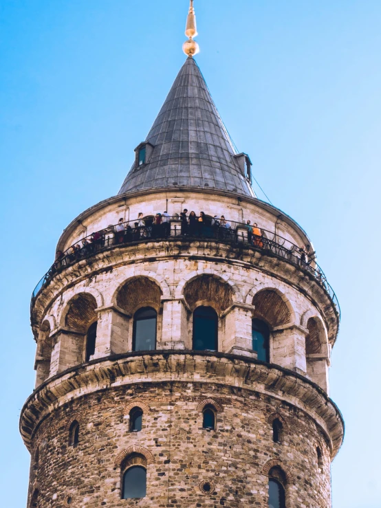 some people sitting on top of a tower looking out at the street