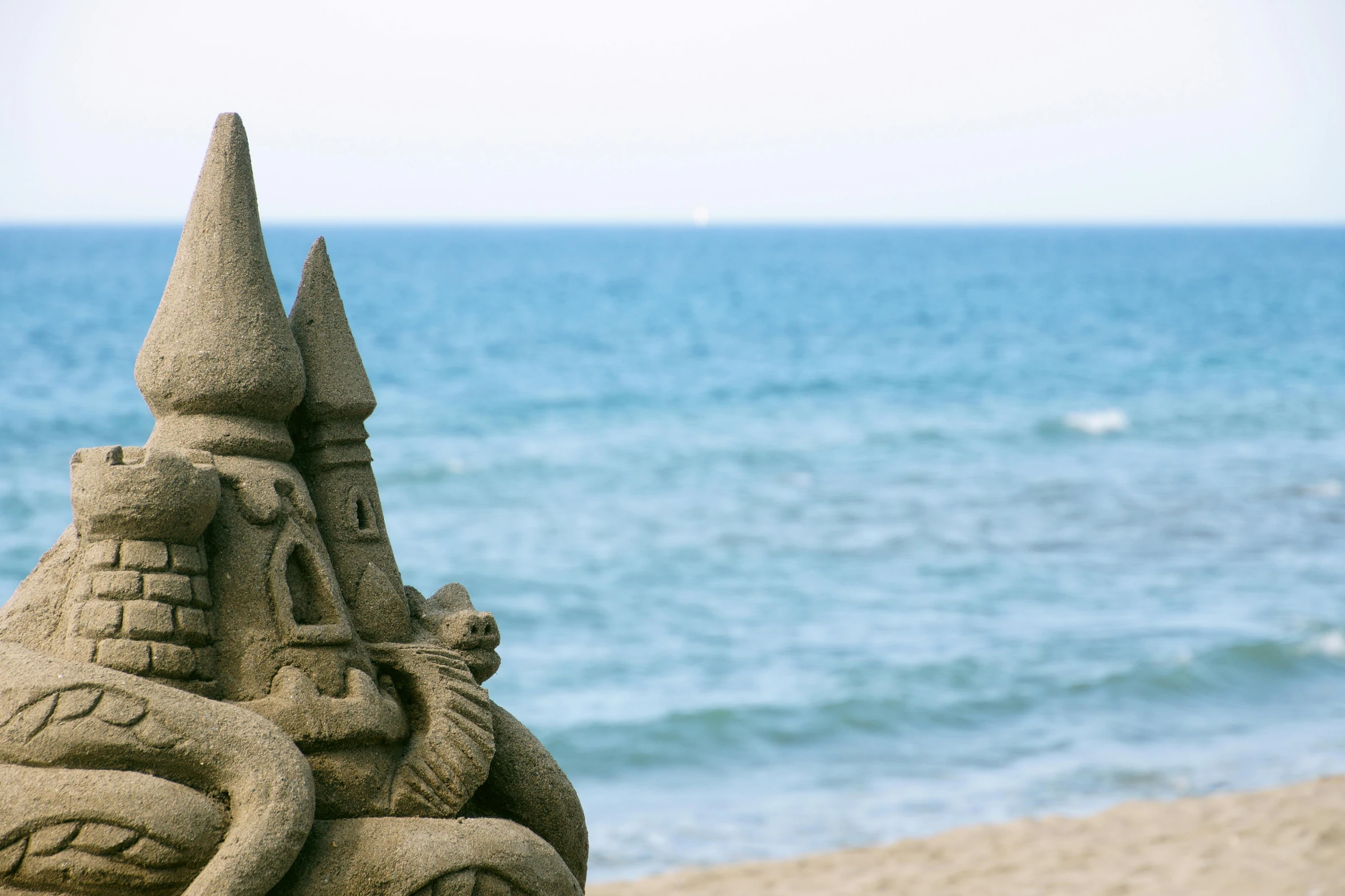 a sand castle by the ocean and sky