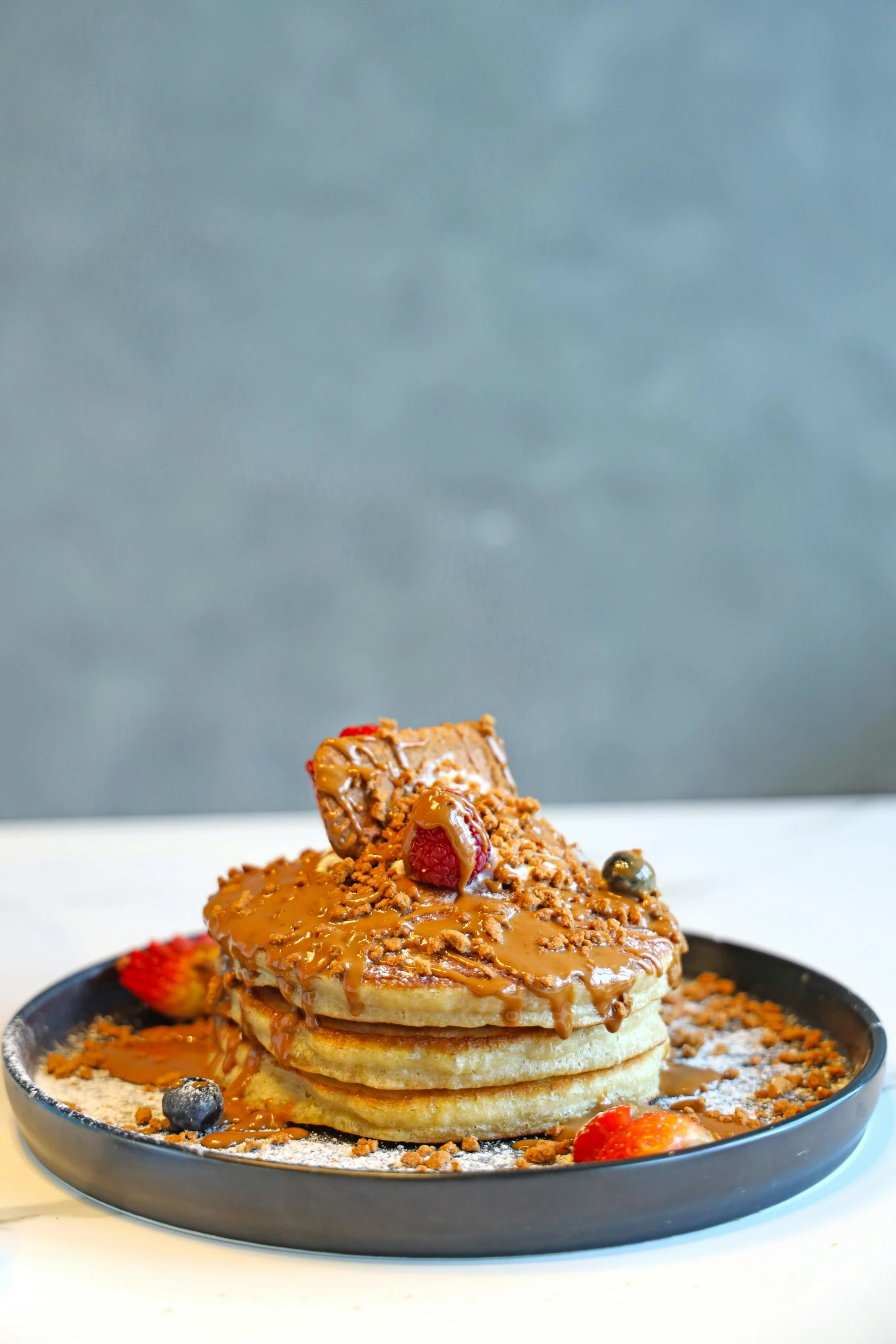 pancakes with chocolate er and fruit are sitting on a plate