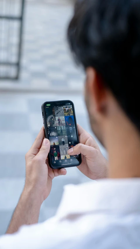 a man in a white shirt looking at a cellphone