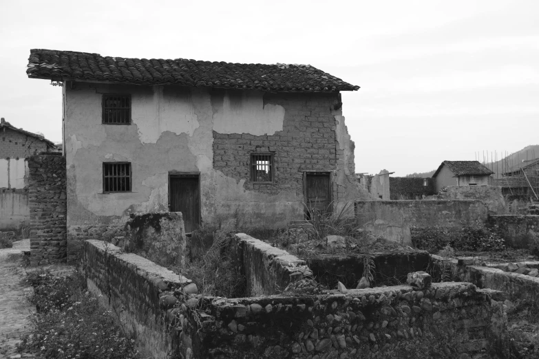 a old house sits in the middle of a barren area