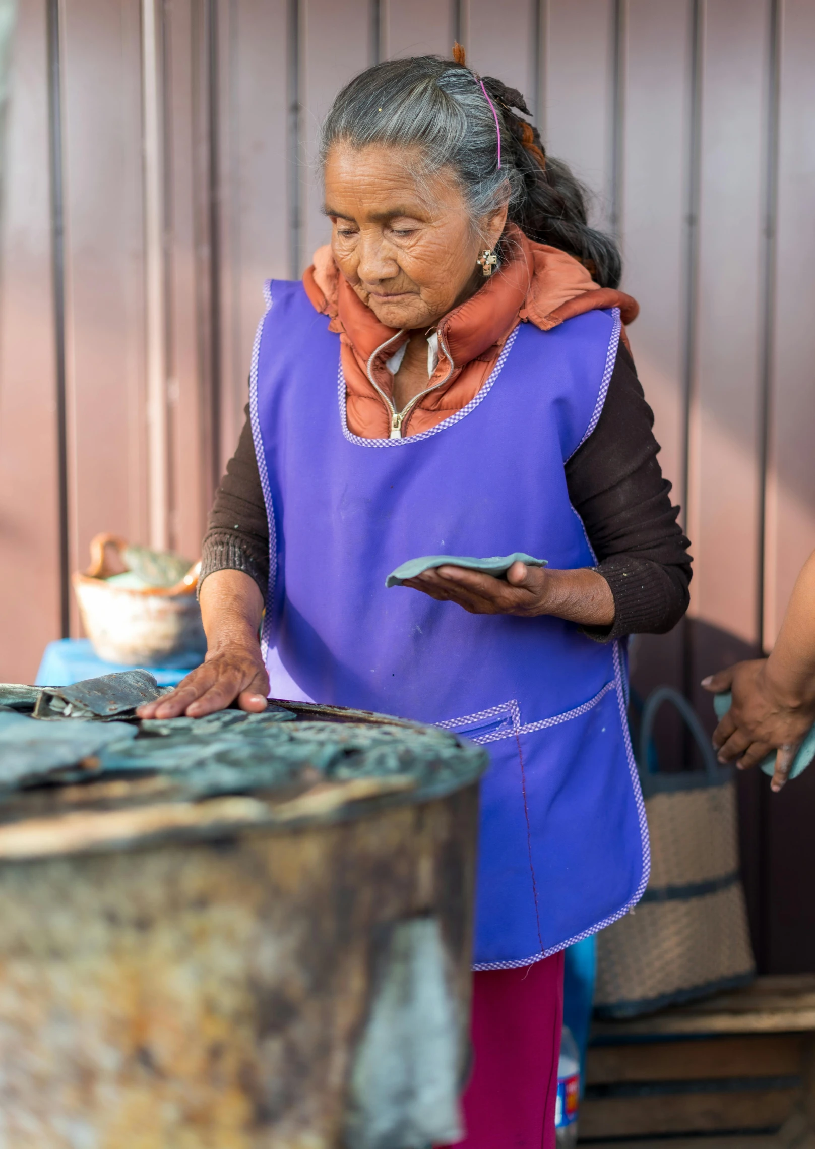 an older woman is standing by a table with plates on it