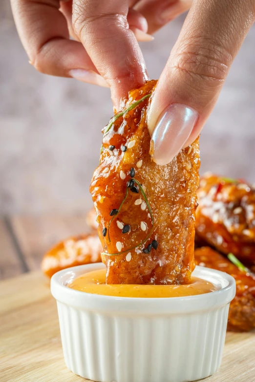 a person dipping sauce onto some kind of food